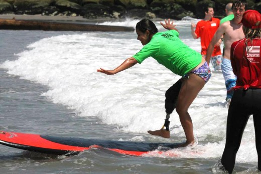 Ana Manciaz, a Wounded Warrior alumna, shows other Warriors how to surf. Photo: Wounded Warrior Project.
