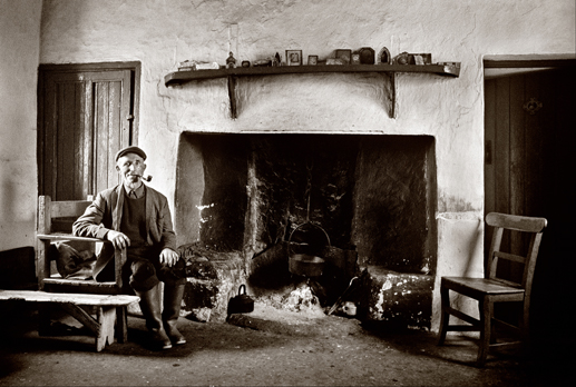 Peatcutter beside his fireplace, Co. Galway, 1971.
