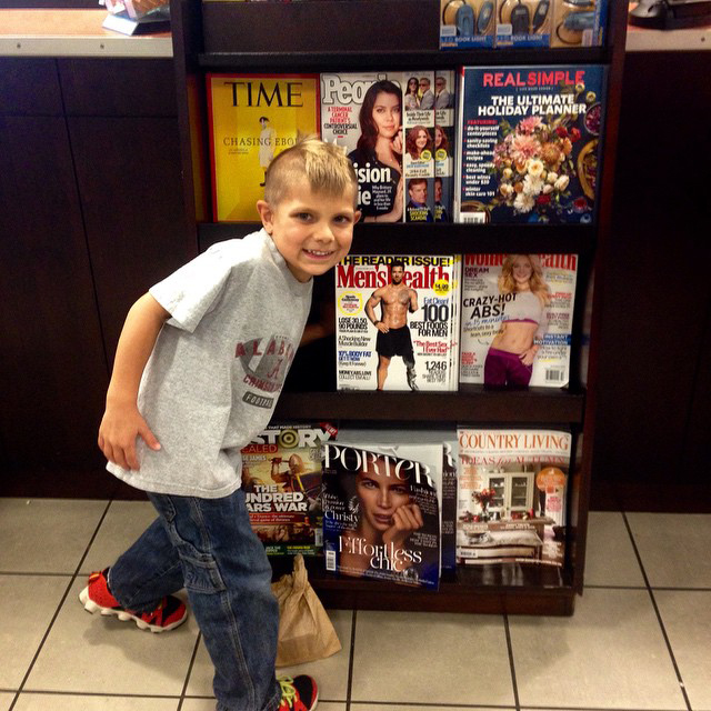 Noah Galloway’s son Jack standing in front of a newsstand displaying his dad on the cover of Men’s Health. (Photo courtesy Noah Galloway)