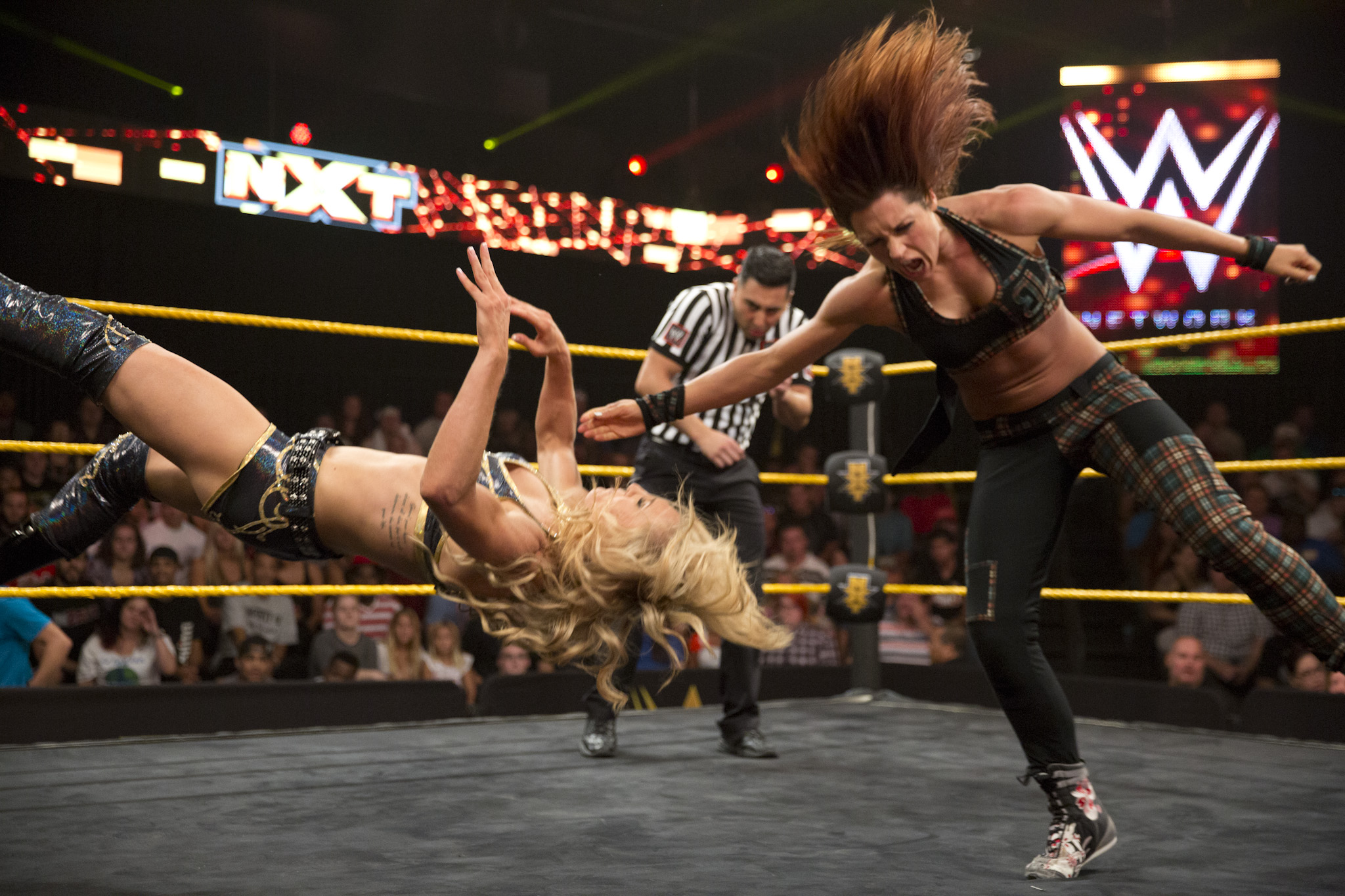 Becky Lynch using her signature move, the “Dis-arm-Her,” on opponent Charlotte Flair.