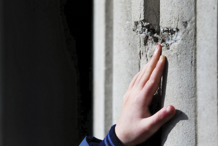 Eamon Heffernan (8) from Limerick touches a bullet hole in the GPO. 