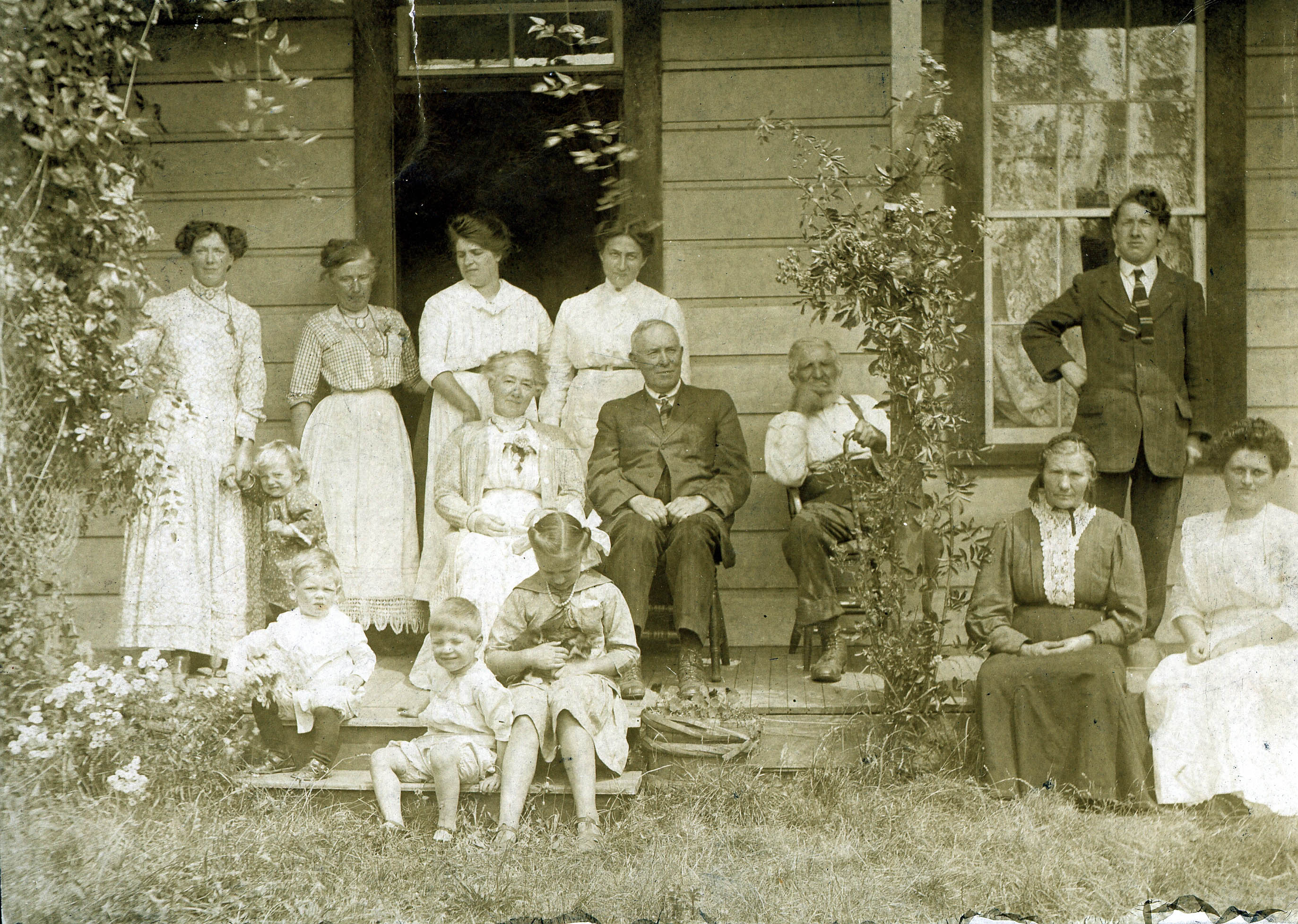 A Ruckle family gathering with friends at the Ruckle homestead, c. 1900. Henry Ruckle is seated left of the post, his wife, Ella Anna, seated to the right. (Photo: Ruckle Family Photographic Collection / Salt Spring Archives)