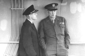 Captain Edmond J. Moran chats with General Eisenhower. Later promoted to Rear Admiral, Moran organized the towing of artificial harbors to the beaches at Normandy, making D-Day landings possible. For his service he was awarded the Legion of Merit, the Croix de Guerre, and the Order of the British Empire.