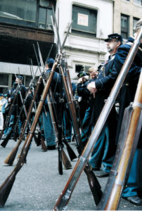 Re-enactors give their muskets a rest while waiting to join the parade.