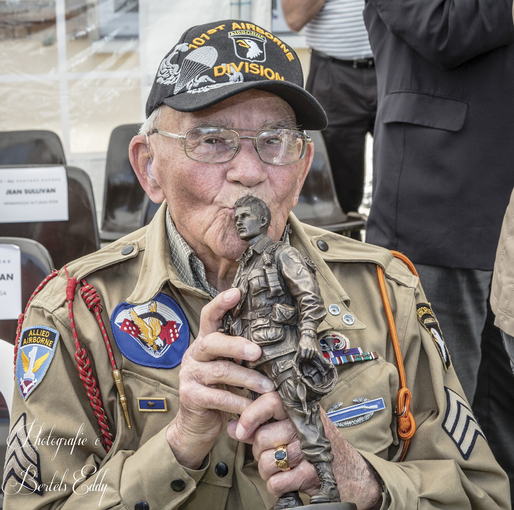 Robert Noody, a veteran from Star Lake, New York, kisses the paratrooper statuette he received at the 2014 ceremony in Ravenoville, Normandy.