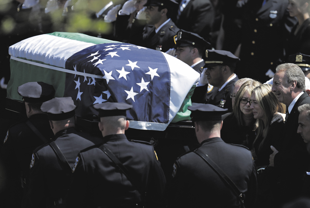 Police officers carry Moore’s coffin from  St. James Catholic Church in Seaford, New York.