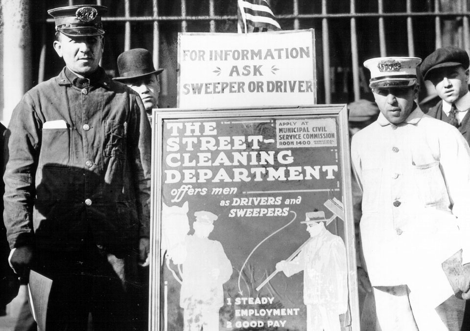 Ambrose’s street cleaning crew with a job advertisement poster.