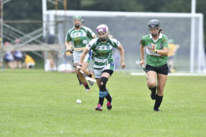 Captain Heather Warren of Coastal Virginia Camogie focuses on winning the ball before a Seattle Gaels camog does.