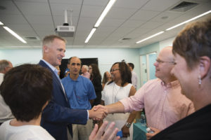 Mike greets a patient with a Boston Scientific stent and his wife, along with other members of the team.