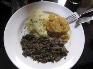 A plate of mashed neeps, tatties and haggis.