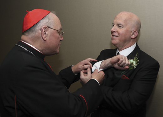 <em>James O'Neill shows his cufflinks to Cardinal Dolan, the Archbishop of New York.</em>