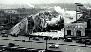 The SS Normandie lies on its side on the Hudson River after a fire aboard the ship.