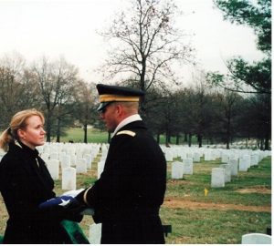 Megan Smolenyak receiving the flag of a soldier at Arlington National Cemetery.