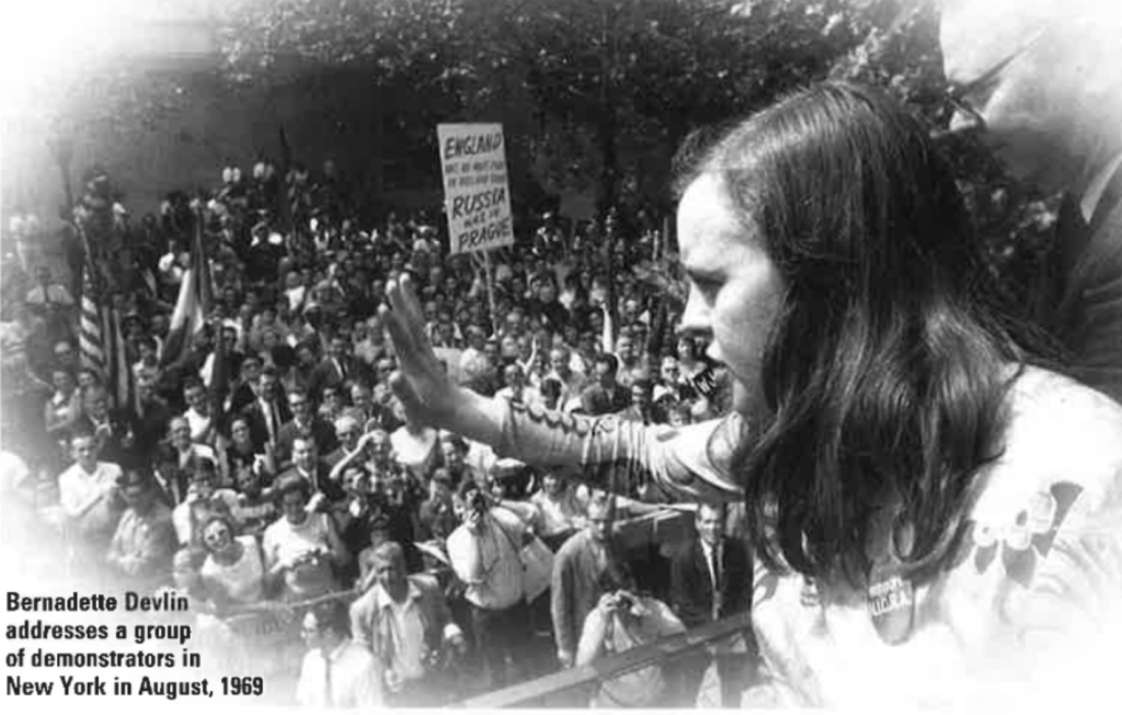 Bernadette Devlin addresses a group of demonstrators from a podium with the palm of her hand held out during a visit to New York in August 1969. 