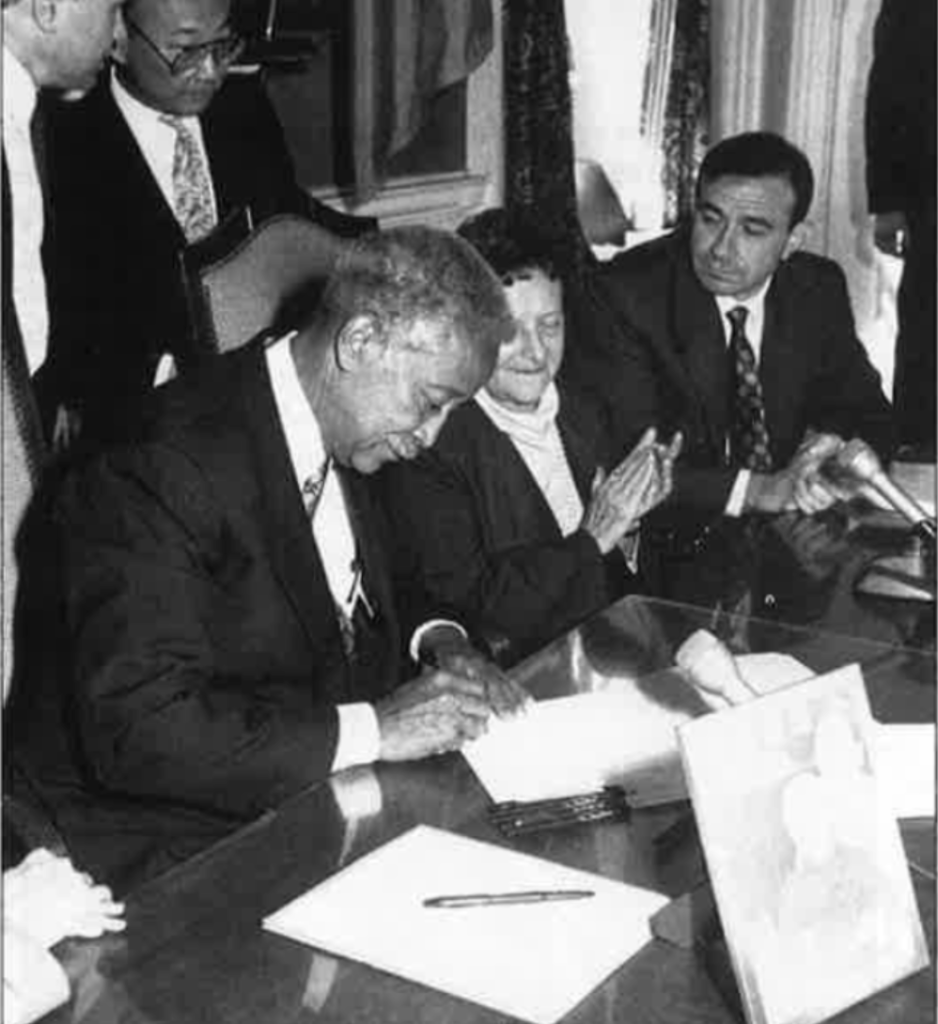 Former NYC mayor David Dinkins signs a document creating the street sign for Joe Doherty on Manhattan's Pearl Street. 