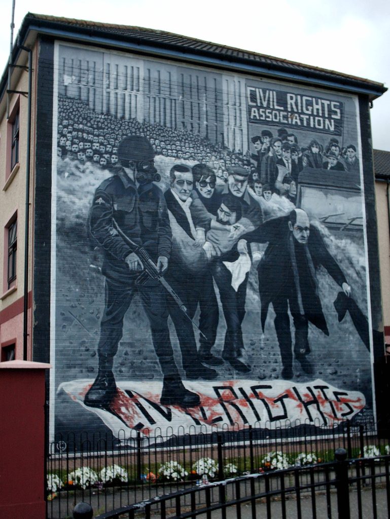 Bogside mural on Lecky Street, Londonderry. The mural depicts the famous photo of Father Edward Daly, waving a blood-stained white handkerchief as he escorts a mortally-wounded protester to safety during the events of Bloody Sunday (1972) in Derry, Northern Ireland.